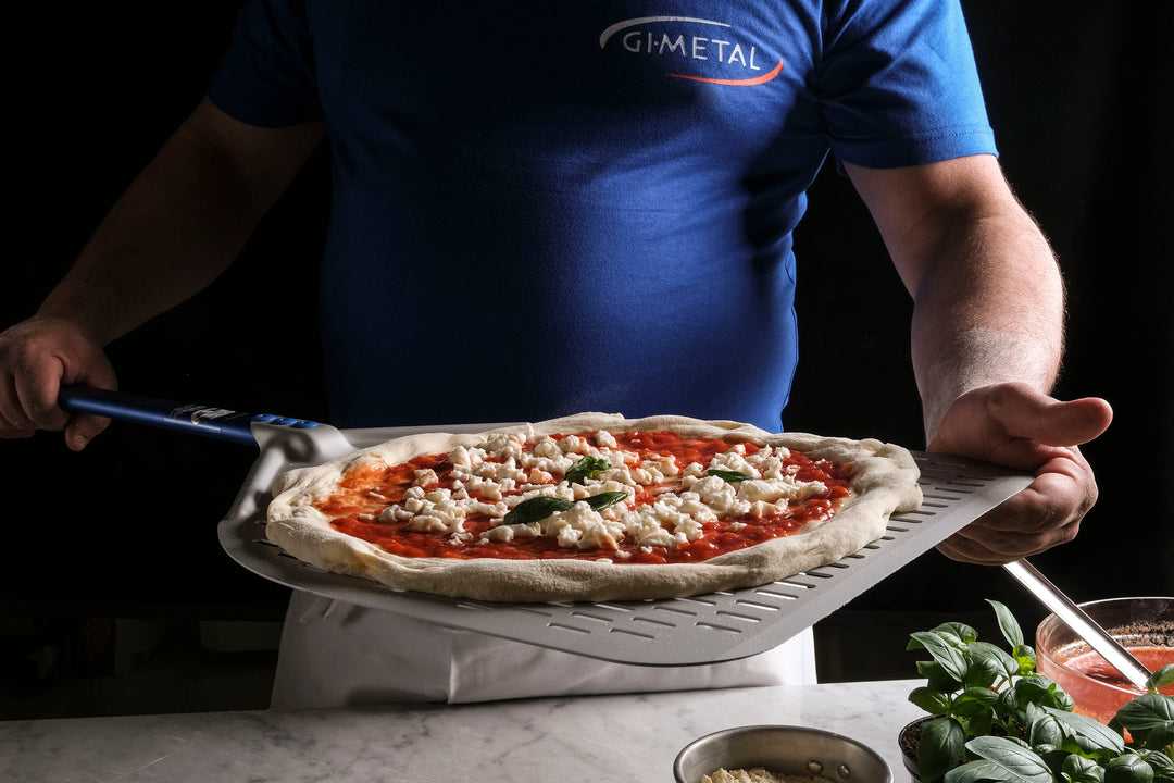 Gi.Metal-pizzaspade i bruk med pizza